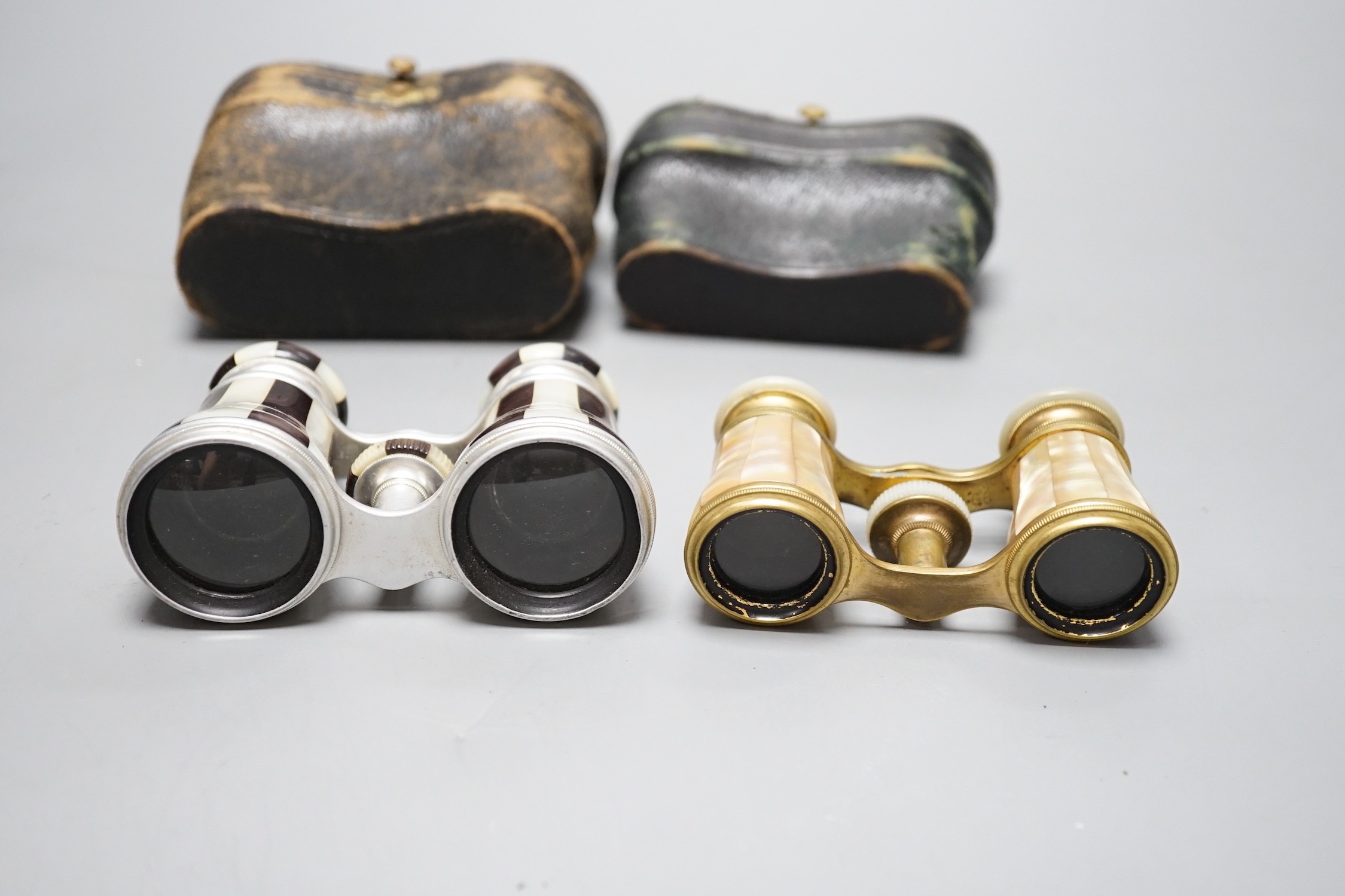 Two pairs of mother of pearl opera glasses; one marked Lemaire Fab, Paris to one lens and F.G. Schmidt, New York to the other, and Marghand Paris to the smaller pair